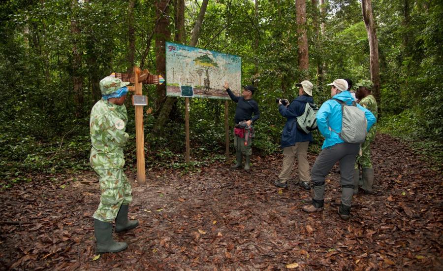 AfriSAR Rainforest Team and ANPN (Agence Nationale des Parcs Nationaux du Gabon) looking at the entrance signs at the Raponda Walker. Arboretum/Mondah Forest.